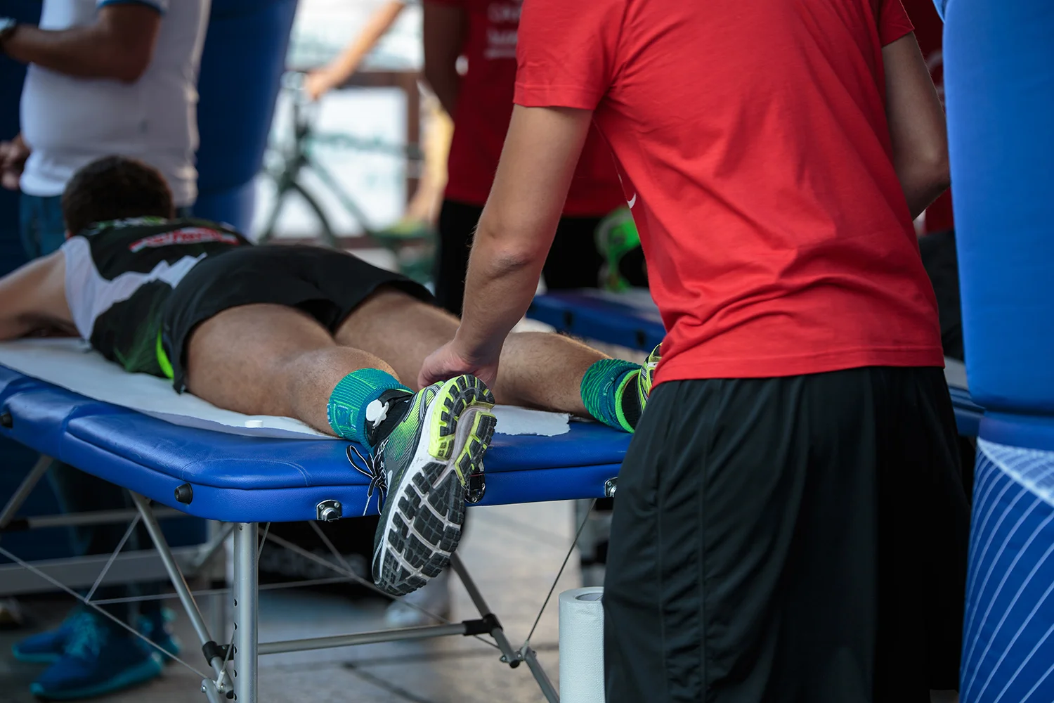 athletic man receives leg massage at sporting even