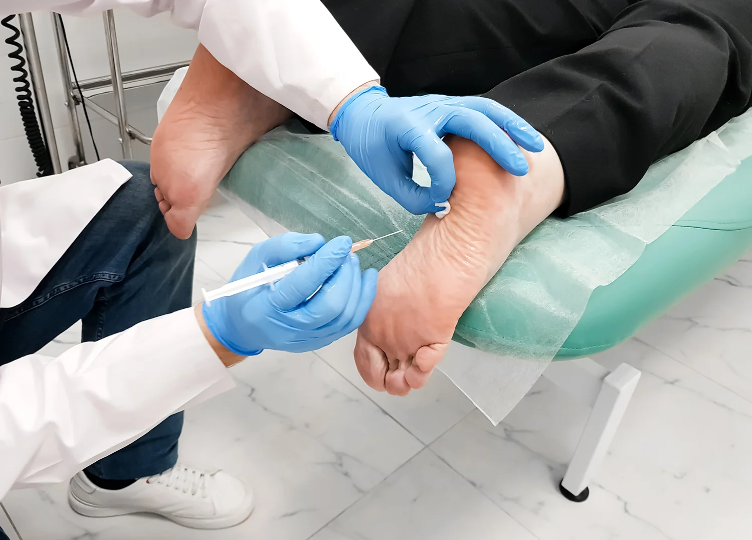 doctor injecting ankle of patient